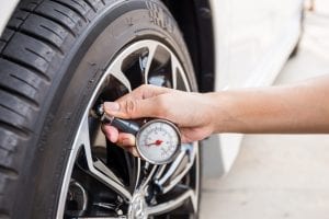 man checking tyre pressure with gauge